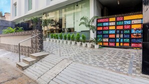 Entrada d'un edifici modern amb un camí empedrat que condueix a uns escalons.