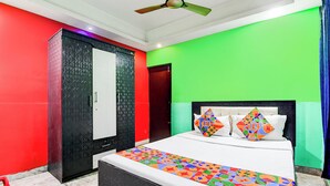 A bedroom with a bed, a wardrobe, and a ceiling fan. - Fabhotel Rose (Barasat)