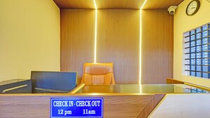 A reception desk with a sign indicating check-in and check-out times. - Fabexpress Ss Residency (Chennai)
