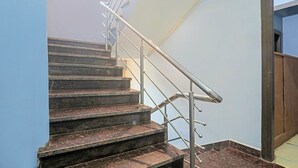 Un escalier avec des rampes en métal et des marches en marbre foncé.