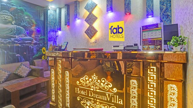 Un comptoir d’accueil d’hôtel orné d’une fresque représentant un Bouddha, avec une enseigne indiquant « hôtels exceptionnels » et un panneau affichant les tarifs des chambres.