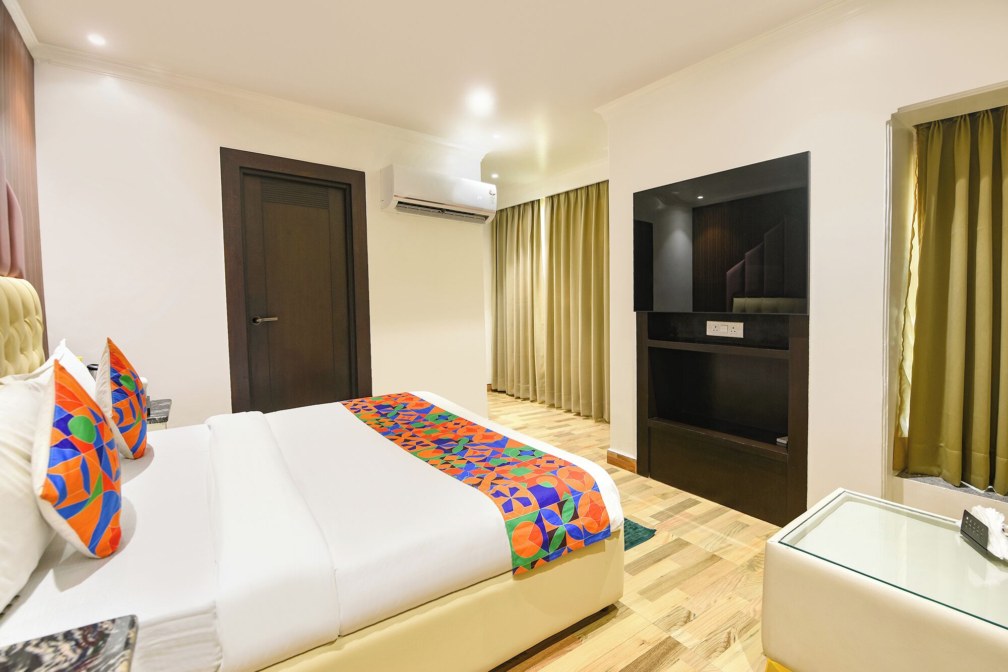 A hotel room with a bed, a TV, a desk, and a wardrobe.
