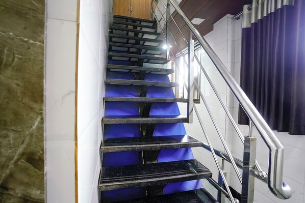 A staircase with blue steps and a metal railing. - Fabhotel Chembur Residency (Mumbai)