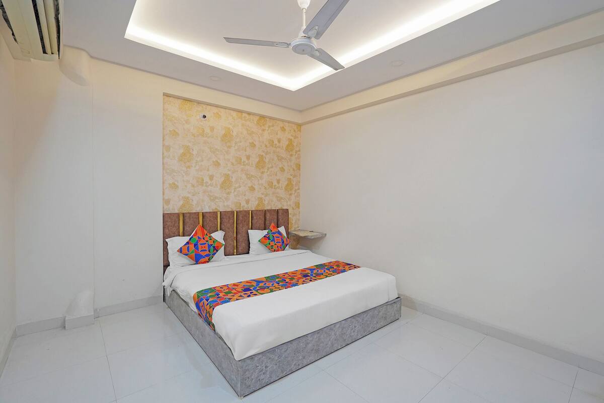 Ein Schlafzimmer mit Bett, Deckenventilator und Wand mit Muster.