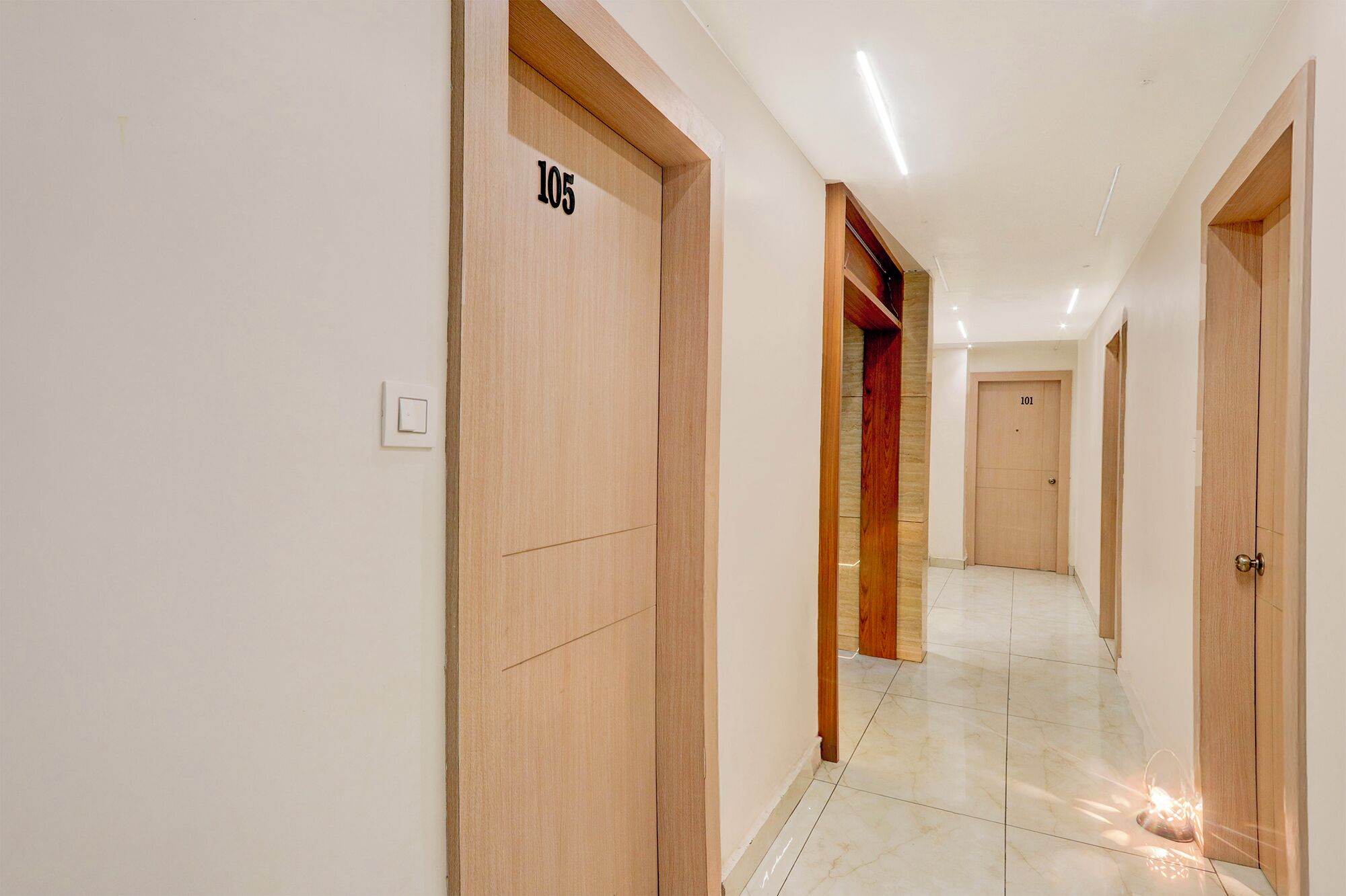 A hallway with wooden doors numbered 105 and 101, leading to rooms.
