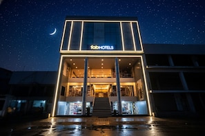 Un edificio moderno con il cartello 'fabHOTELS', caratterizzato da una scalinata centrale e diversi piani.