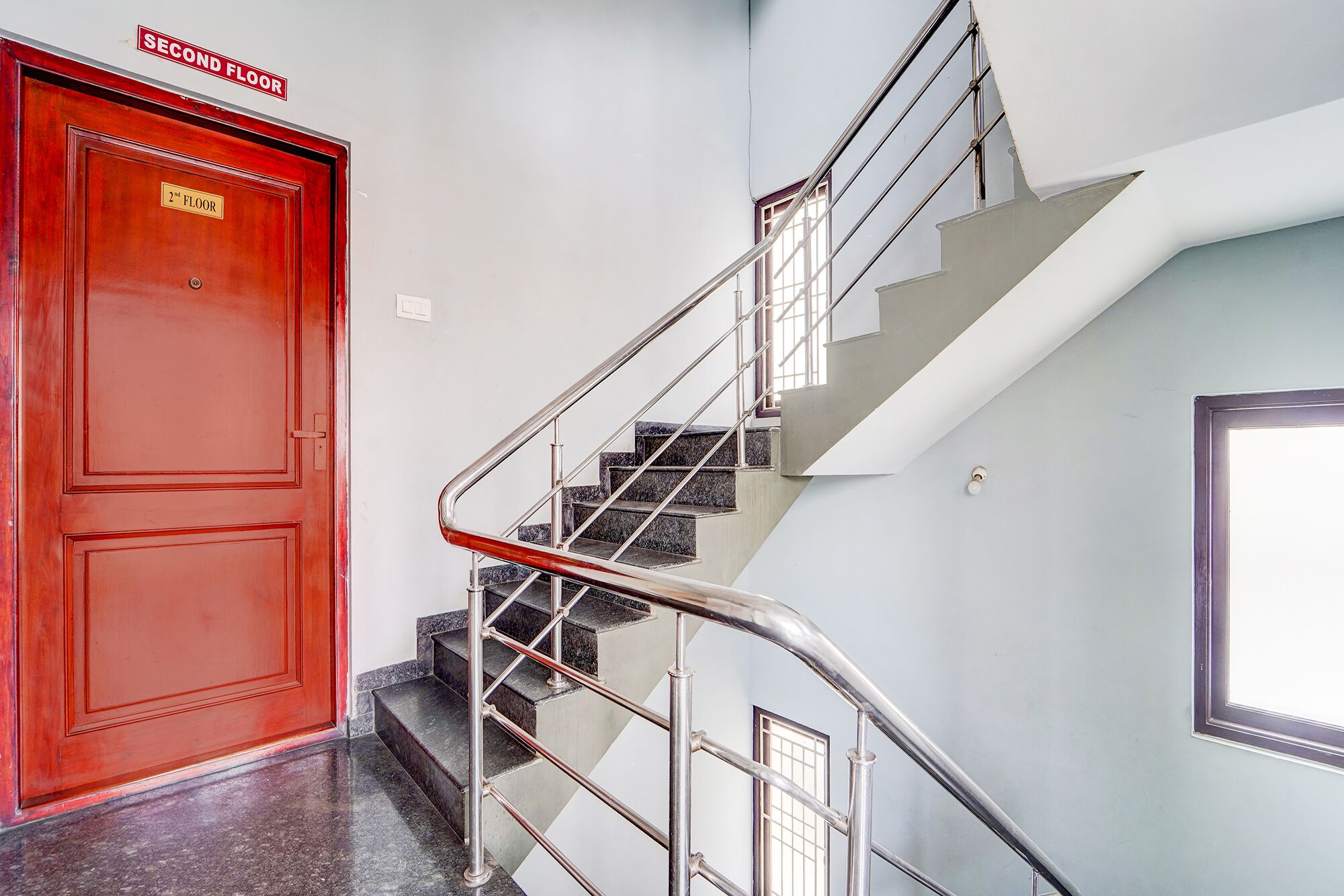 A staircase with metal railings leading to a second-floor door.