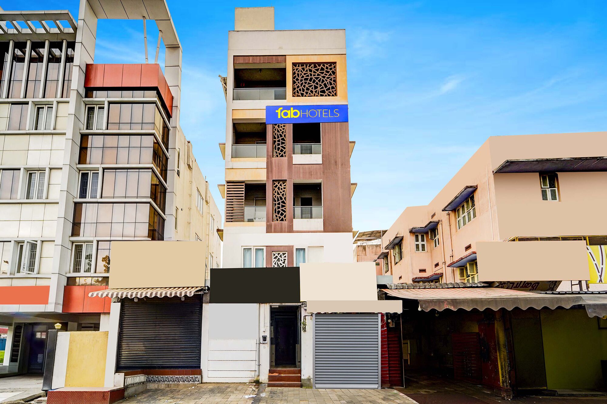 A multi-story hotel with a modern facade, a visible sign for '1abHOTELS', and a gated entrance.