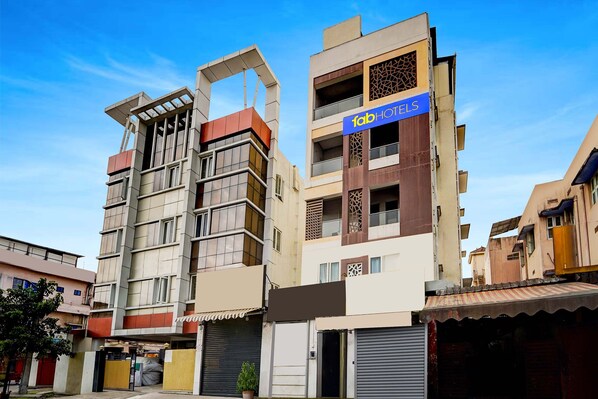 Um hotel de vários andares com fachada moderna, com varandas e uma placa chamativa para 'fabHOTELS'.