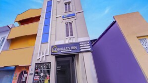 A building with a sign for 'Ishika's Inn' featuring a 'Feel like home' tagline.