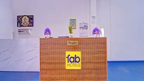 A reception desk with a wooden panel and a sign for Fab Hotels.