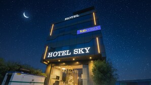 A modern hotel named "Hotel Sky" with a clear night sky and a crescent moon. - Fabhotel Sky I (Gurugram)
