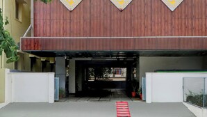 A building entrance with three diamond-shaped signs with a letter 'R' on a wooden facade. - Fabhotel Radha Rani Residency (Khammam)