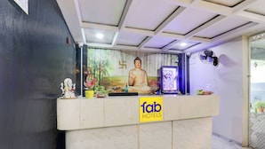 A hotel reception desk with a Buddha statue, a small shrine, and a sign for 'fab hotels'. - Fabhotel Radha Rani Residency (Khammam)