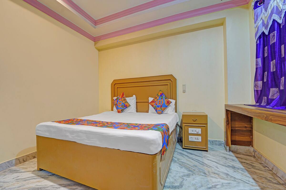 A neatly arranged bedroom with a bed, bedside table, and a desk.