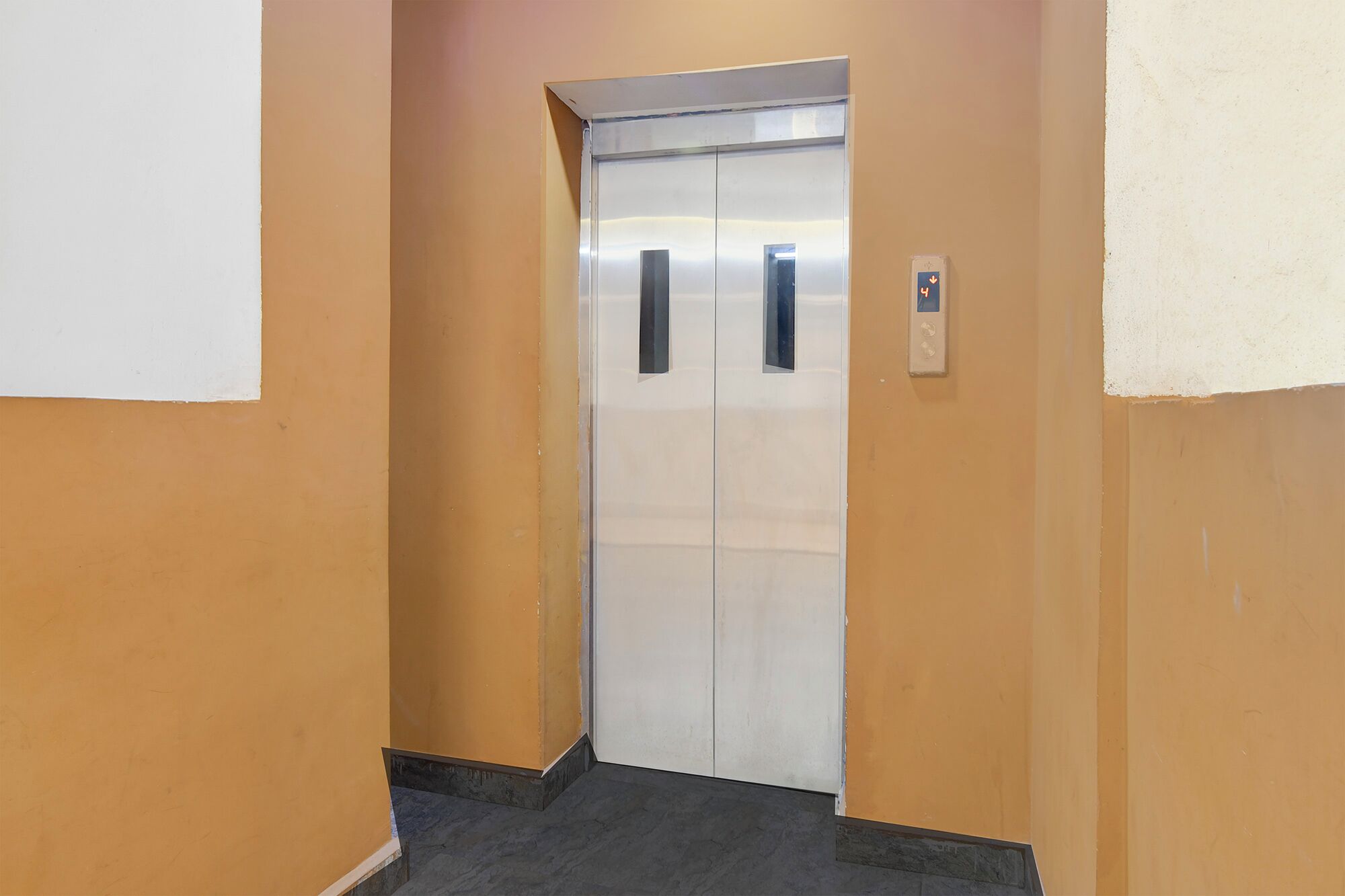 A narrow hallway with a closed elevator door.