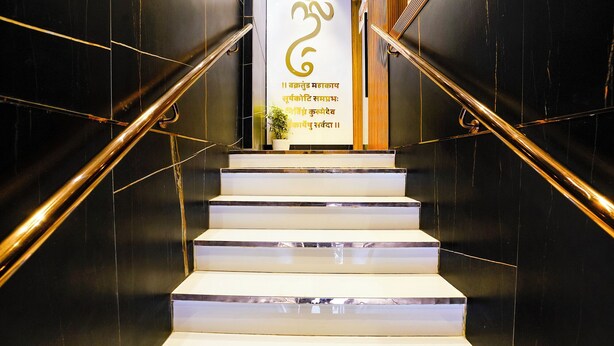 A staircase with marble steps and golden handrails, leading to a sign with text in a non-Latin script. - Fabhotel Nexus Inn (Mumbai)