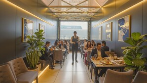 A modern dining area with a central serving station, tables with diners, and large potted plants. - Fabhotel Nexus Inn (Mumbai)