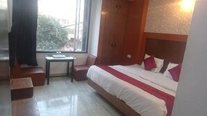 A hotel room with a bed, a small table, and a window. - Fabhotel Rk Retreat (Bhopal)