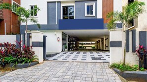 A modern building with a checkered tile entrance, potted plants, and a fire extinguisher on the wall. - Fabhotel Casa Grand (Hyderabad)