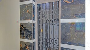 A room with a metal gate and marble-patterned walls. - Fabhotel Srikara Grand Luxury Rooms (Hyderabad)