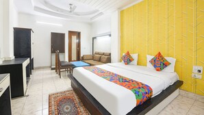 Una habitación de hotel con cama, escritorio, silla y sofá.