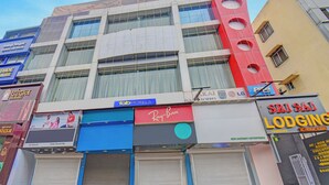A multi-story building with various businesses including a hotel, a sports center, and a jewelry store. - Fabhotel Sri Sai (Pune)
