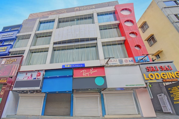 A multi-story building with various businesses including a hotel, a sports center, and a jewelry store. - Fabhotel Sri Sai (Pune)