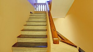 A staircase with wooden handrails and a white wall. - Fabhotel 4 Pillar's - Nr Big Daddy Casino, Panaji (Panaji)