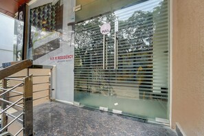 A building entrance with a 'PULL' sign, a glass door, and a sign reading 'N.R.M. RESIDENCY affordable luxury'. - Fabhotel Nrm Residency (Mysore)