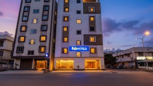 A multi-story building with a 'fabHOTELS' sign, featuring a modern architectural design with a flat roof and a mix of window sizes. - Fabhotel Leon Square (Bengaluru)