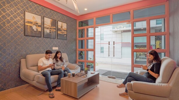 Una sala de estar moderna con sofá, mesa de centro y ventanas amplias.