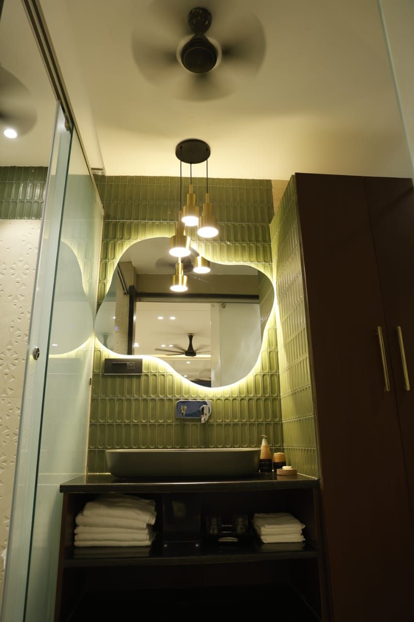 Un baño con un tocador moderno, un espejo grande y un ventilador de techo.