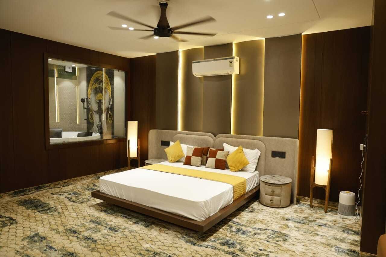 A modern bedroom with a large bed, a ceiling fan, an air conditioning unit, and a marble-patterned floor.