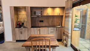Una cocina compacta con muebles de madera, una mesa y sillas.