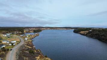 A coastal town with a river, houses, and a road curving along the water.