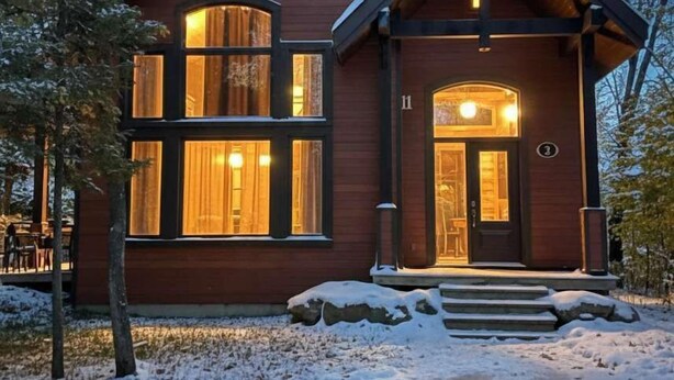 A wooden cabin with large windows, a front door, and a number '11' on the wall. - Nature & confort | Refuge L'Equilibre (Scott)