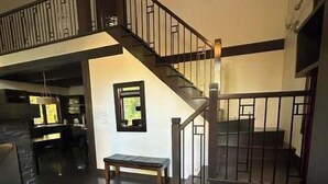A spacious interior with a staircase, a bench, and a kitchen area. - Nature & confort | Refuge L'Equilibre (Scott)