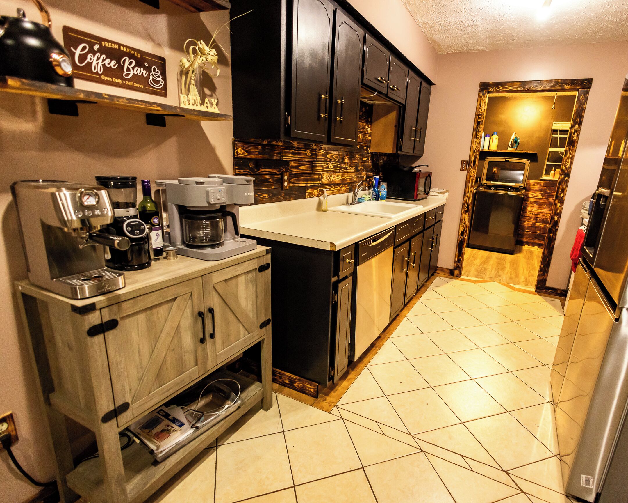 A modern kitchen with a coffee machine, a microwave, and a refrigerator.