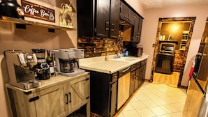 A modern kitchen with a coffee machine, a microwave, and a refrigerator.