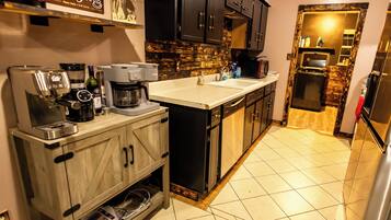 A modern kitchen with a coffee machine, a microwave, and a refrigerator.