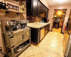 A modern kitchen with a coffee machine, a microwave, and a refrigerator.