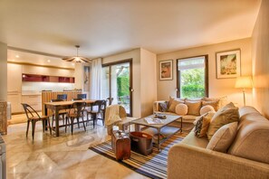 A modern living room with a sofa, coffee table, and dining area. - Deauville Lovely Flat With Private Garden (Tourgeville)