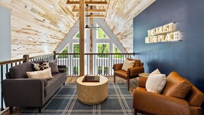 Un interior moderno con techo de madera, pared de acento azul y un cartel que dice 'THIS MUST BE THE PLACE'.