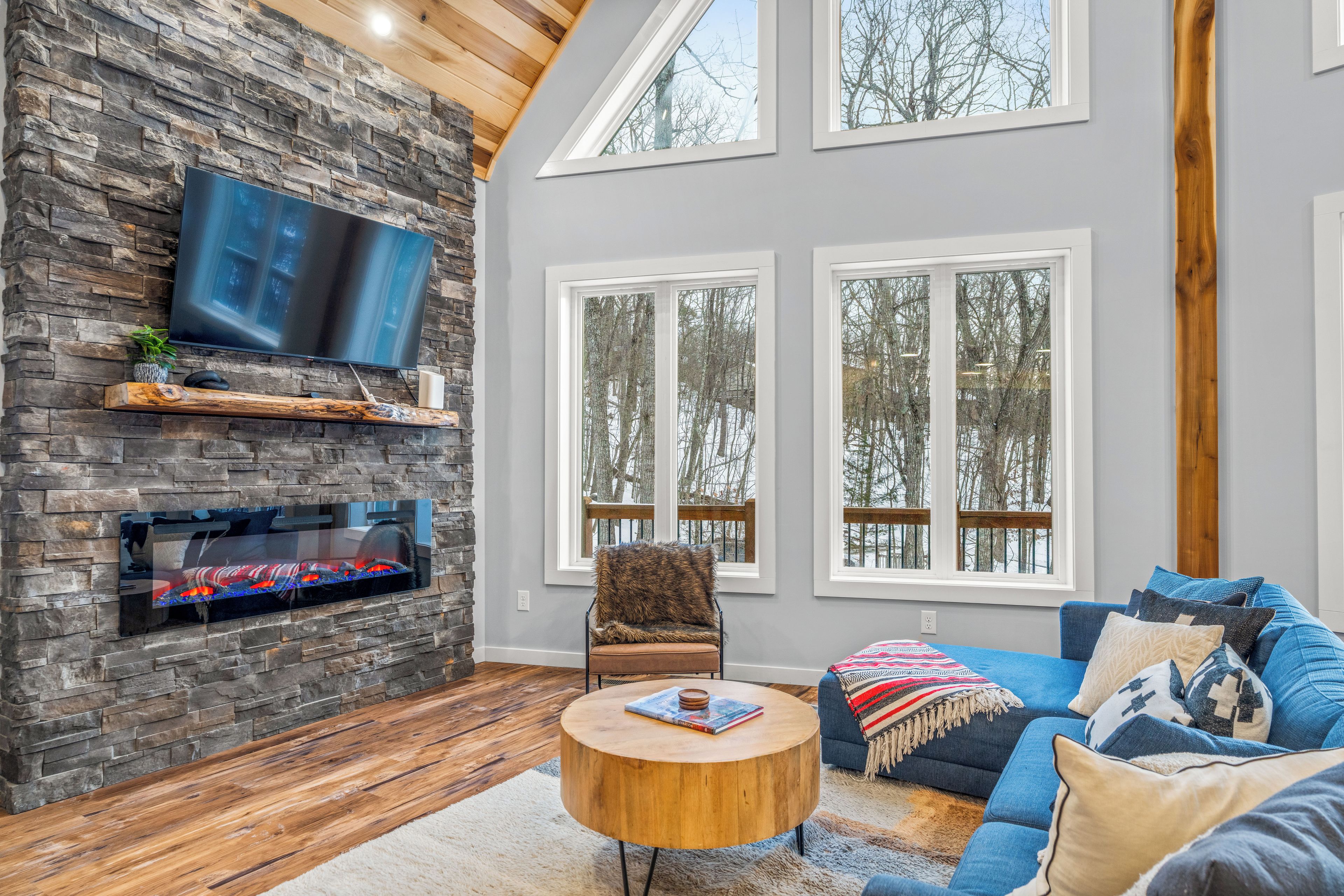 Relax by the warmth of this cozy living room while taking in the snow covered trees outside.