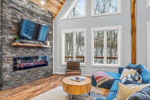 Relax by the warmth of this cozy living room while taking in the snow covered trees outside. - The Chalet~Resort~Pool~HotTub~GameRoom~FirePit (McGaheysville)
