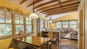 A kitchen with wooden floors, a central island, and large windows. - New Listing! Charming Moab Hideaway | Steps from Main Street (Moab)