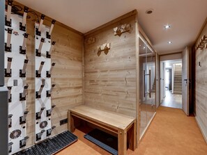 Un baño moderno y minimalista con paneles de madera, un banco y cabina de ducha de vidrio.
