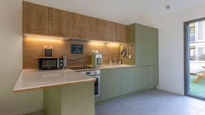 A modern kitchen with wooden cabinets, a microwave, a coffee maker, and a sink.