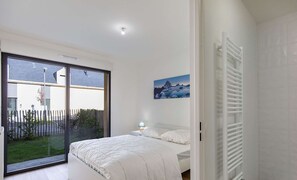 Une chambre à coucher avec un lit, une fenêtre, un tableau et un radiateur.